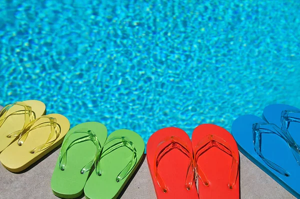 Gekleurde Teenslippers Van Een Gezin Van Vier Bij Het Zwembad — Stockfoto