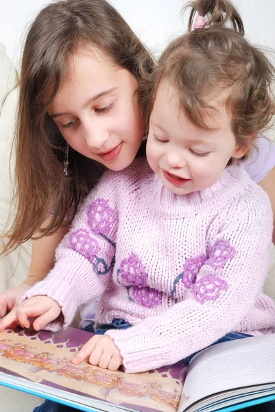 Hermanas Sentadas Salón Leyendo Libro —  Fotos de Stock