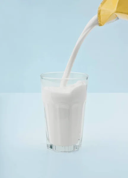 Ein Glas Frische Milch Auf Den Küchentisch Gießen — Stockfoto