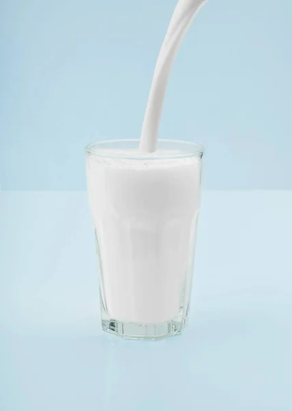 把一杯鲜牛奶倒在厨房桌子上 — 图库照片