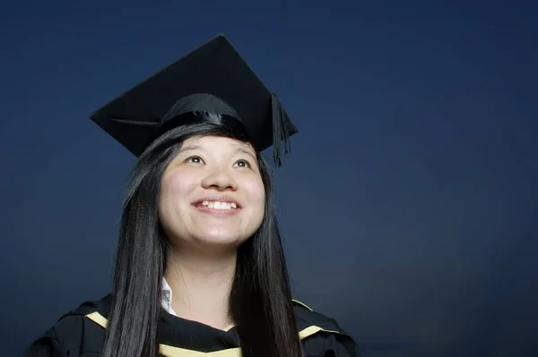Uśmiechnięta Azjatka Absolwentka Patrząc Górę Aspiracjami Ciemnym Tle Nieba — Zdjęcie stockowe