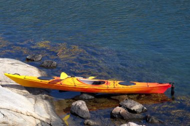 kayak on a rocky shore clipart