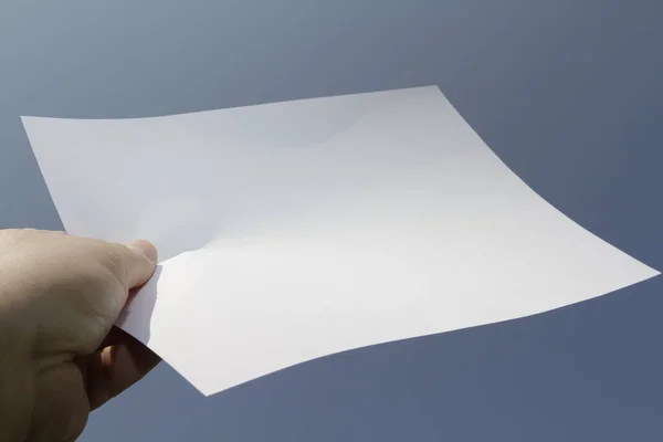 Een Wit Velletje Papier Wordt Met Één Hand Lucht Gehouden — Stockfoto