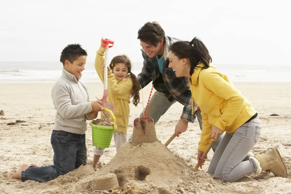 Famiglia Costruzione Sandcastle Sulla Spiaggia Invernale Immagine Stock