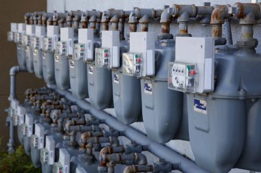 Two Rows of gray gas meters at an apartment complex clipart