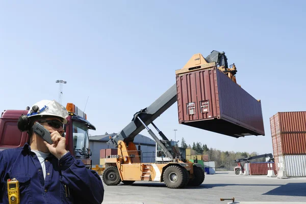 フォークリフトを指示する労働者 忙しい商業用コンテナポートに貨物コンテナを積み重ねる — ストック写真
