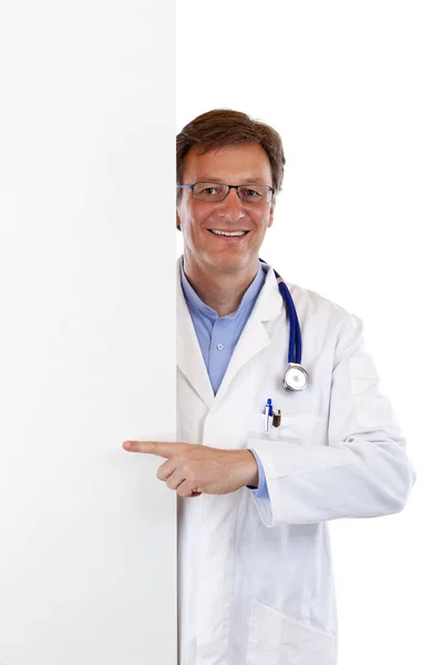 友善的 年长的医生用手指在空白的广告牌上指尖 在白色背景下隔离 — 图库照片