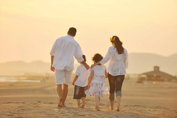 幸せな若い家族はビーチランを楽しんで日没にジャンプします — ストック写真