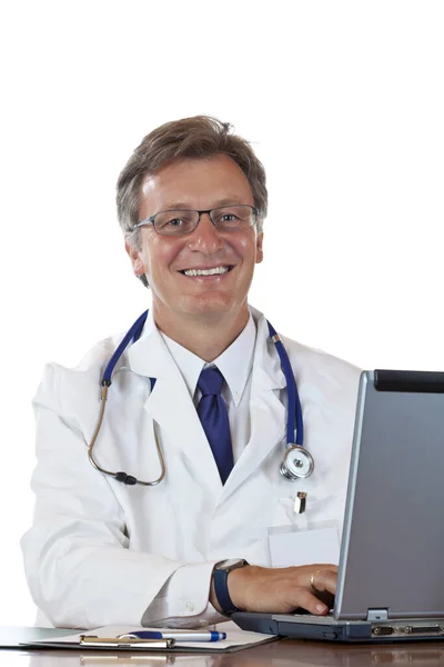 Dojrzały Sympatyczny Lekarz Pisze Uśmiechając Się Receptury Laptopa Izolowany Białym — Zdjęcie stockowe