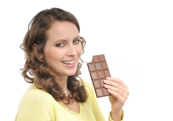若いです笑顔女性で黄色食べるミルクチョコレート隔離された白い背景 — ストック写真