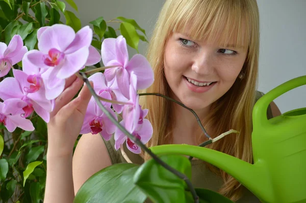 young attractive woman pouring orchids