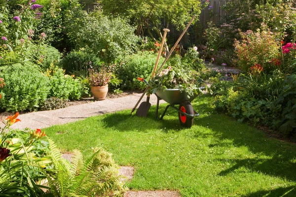 早晨在夏日花园工作 手推车 铲子和铲子 — 图库照片