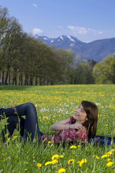 Young Woman Relaxing Spring Meadow ロイヤリティフリーのストック画像