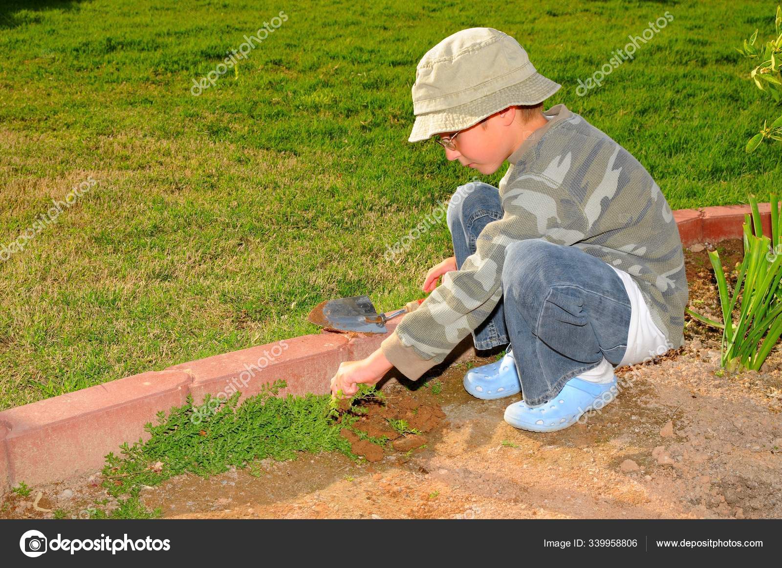 Young Boy Pulling Weeds Garden — Stock Photo © PantherMediaSeller #339958806, image size:1600x1163