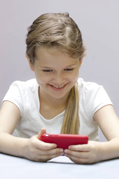 携帯電話で遊んでいた7歳の女の子が — ストック写真