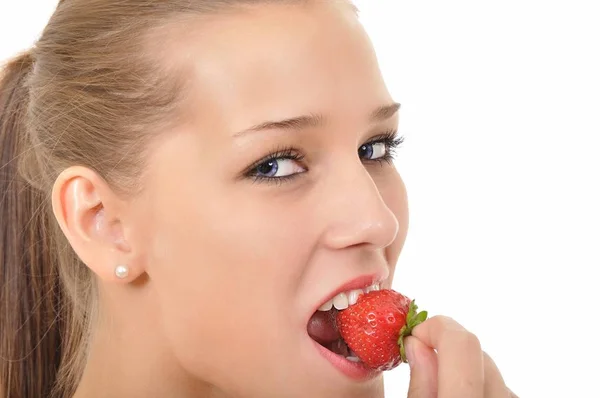 一个蓝眼睛的年轻女人咬着草莓 — 图库照片