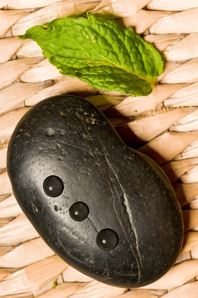 Zwarte Spa Steen Met Een Groen Blad Houten Weef — Stockfoto