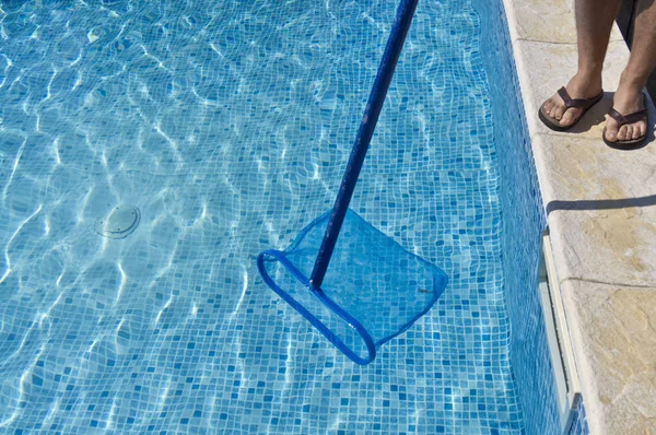 プールを掃除する男と水の縫い目は非常に明るい — ストック写真