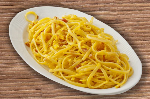 Typisch Italienische Pasta Einem Weißen Ovalen Teller Über Einer Holzmatte — Stockfoto