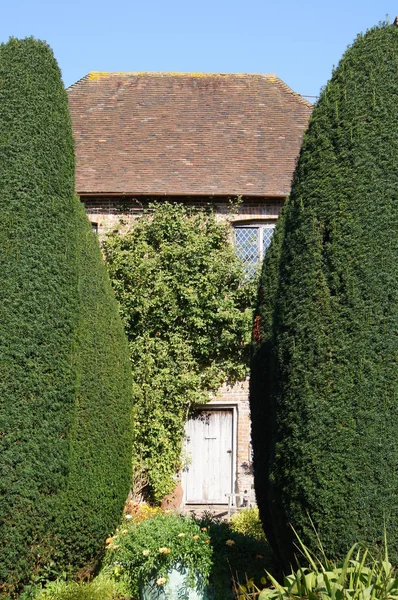 Hübsches Englisches Landhaus Versteckt Hinter Hohen Abgeschnittenen Nadelbäumen — Stockfoto