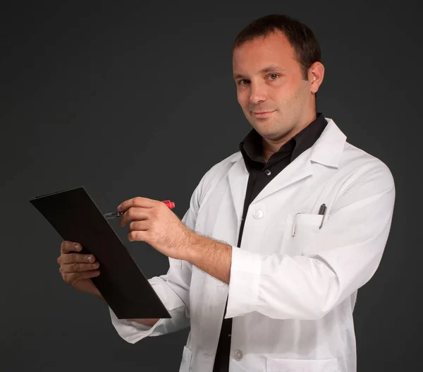 Vrolijke Man Met Een Medisch Uniform Die Aantekeningen Maakt — Stockfoto