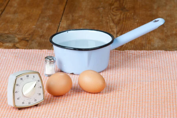 two eggs with pot and egg timer