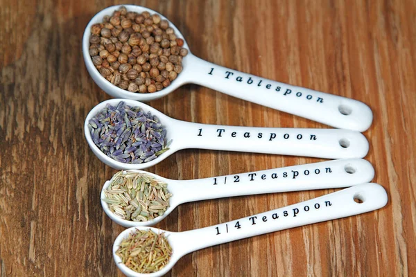 Old table-top selection of herbs and grains in measuring spoons