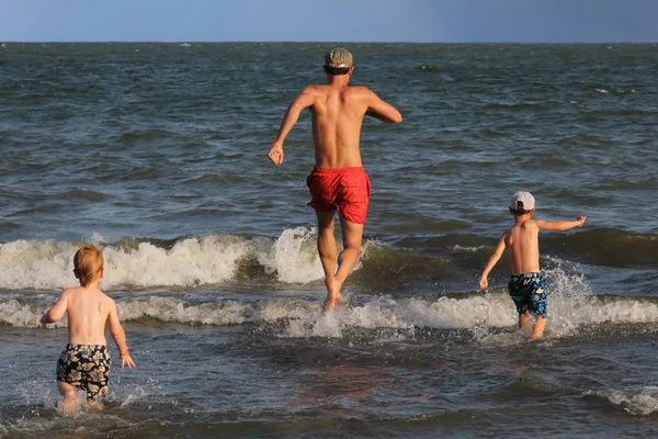 Πατέρας Και Δύο Γιοι Του Τρέχουν Στον Ωκεανό Και Διασκεδάζουν — Φωτογραφία Αρχείου