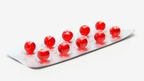 白い背景で隔離赤い錠剤のパック — ストック写真