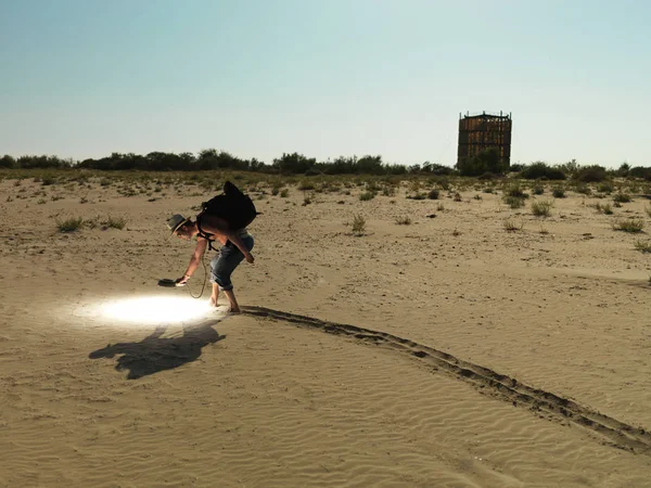 Jovem Com Mochila Procurando Pela Areia Com Uma Luz Brilhante — Fotografia de Stock