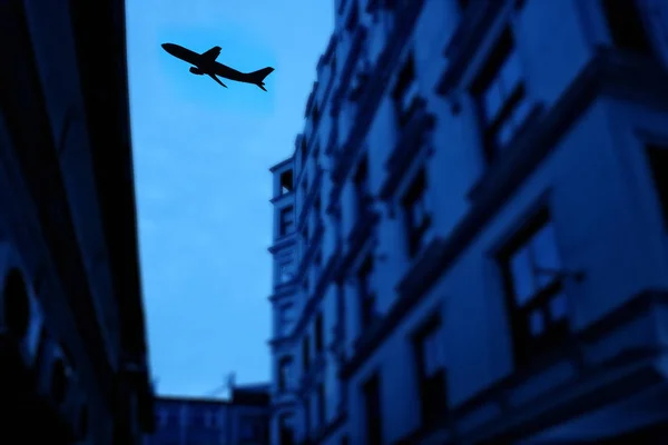 ビルの上を飛行する商業用飛行機のシルエット — ストック写真