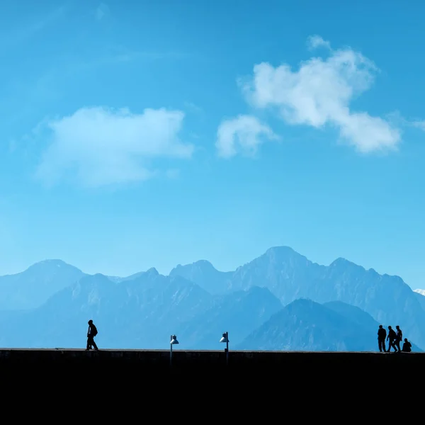 Silhouette Persone Rilassanti Sulla Strada Sopra Cielo Blu Alte Montagne — Foto Stock