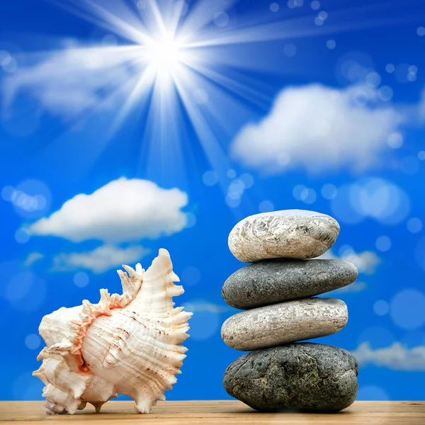 close up shot of stone pile and seashell over sunny sky.