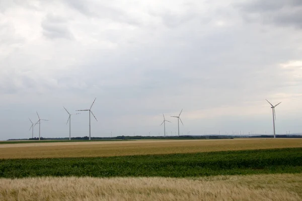 夏の初めは曇りの空に風力発電機が設置された平地で — ストック写真