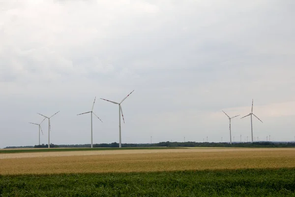 夏の初めは曇りの空に風力発電機が設置された平地で — ストック写真
