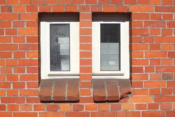 narrow windows with brick house wall