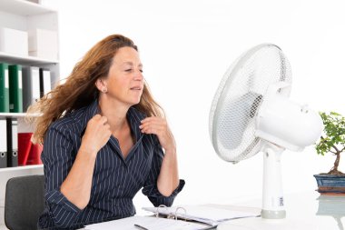 business woman with ventilator at his desk in summerly hot office clipart