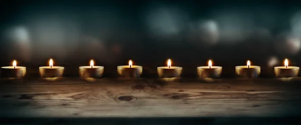 燃烧着暗蓝色背景的蜡烛和木制桌子 作为装饰之间的装饰 — 图库照片