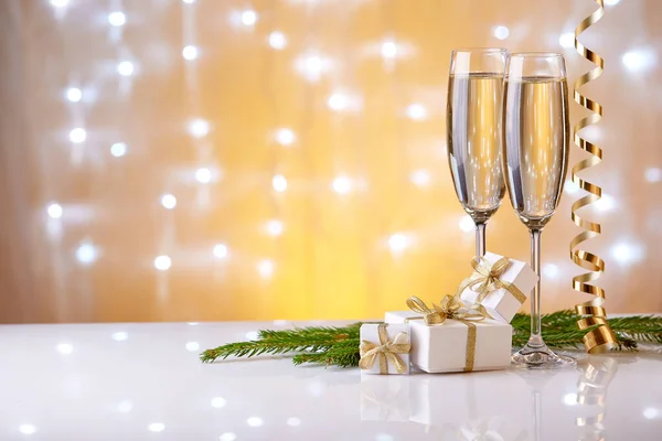 Twee Glazen Met Champange Sparren Tak Geschenkdozen Kerstversieringen Een Gele — Stockfoto