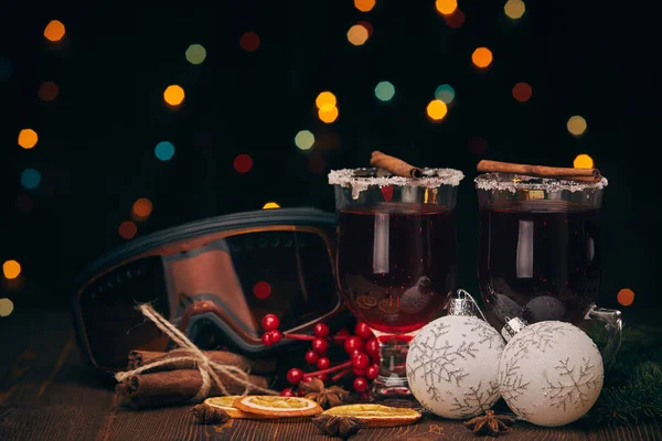 庭の光と暗い背景に木製のテーブルの上に溶融ワイン モミの枝 スキーグラスやクリスマスの装飾 冬休み — ストック写真