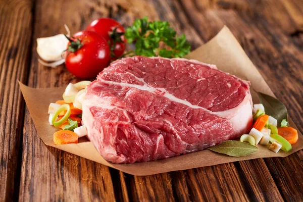 Zöldségekkel Díszített Nyers Húsdarab Asztalra Közelről Nézve — Stock Fotó