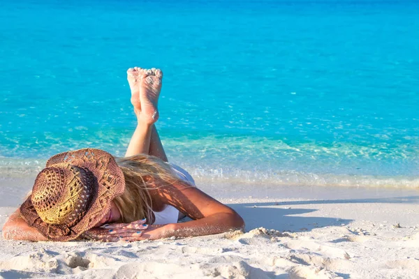 金发女人头戴礼帽躺在沙滩上 — 图库照片