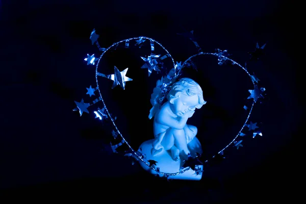 Figurka Śpiącego Anioła Niebieskim Tle Wokół Cheruba Jest Świąteczna Srebrna — Zdjęcie stockowe