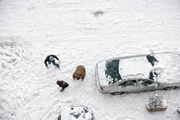 儿童在积雪覆盖的停车场玩耍的高光 — 图库照片