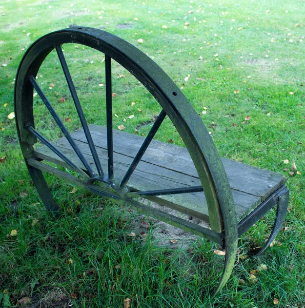 庭の車輪からベンチ 背景には草がある — ストック写真