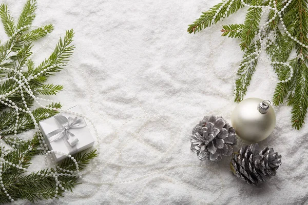 Tannenzweige Mit Dekorationen Und Geschenkschachtel Auf Schneebedecktem Hintergrund Mit Kopierraum — Stockfoto
