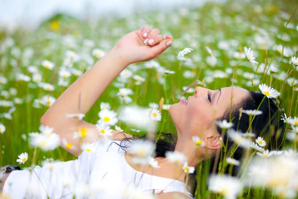 提出された花の上に横たわる美しい女性 — ストック写真