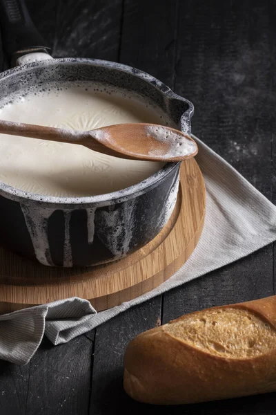 Gekookte Melk Een Zwarte Pan Gemorst Randen Een Houten Snijplank — Stockfoto