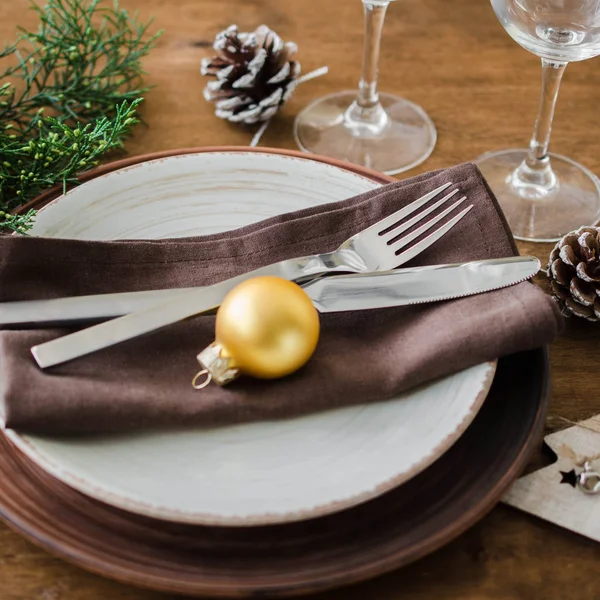 简单的圣诞餐桌的地方设置在木制背景的复古或乡村风格 为圣诞节或新年晚餐准备的节日餐桌 — 图库照片