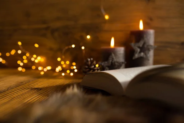 圣诞烛光和一本书在一个温暖的冬夜 田野纵深 令人惬意 — 图库照片